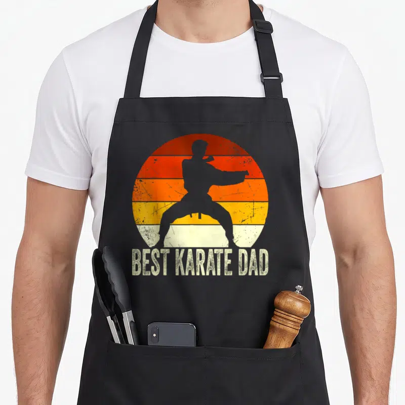 Tablier de cuisine noir avec silhouette karatéka et texte Best Karate Dad sur fond orange rétro.
