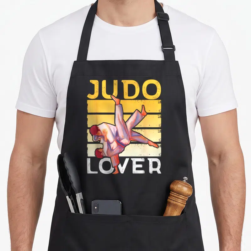 Tablier de cuisine noir avec illustration vintage de deux judokas et le texte « Judo Passionné » imprimé en orange et blanc.