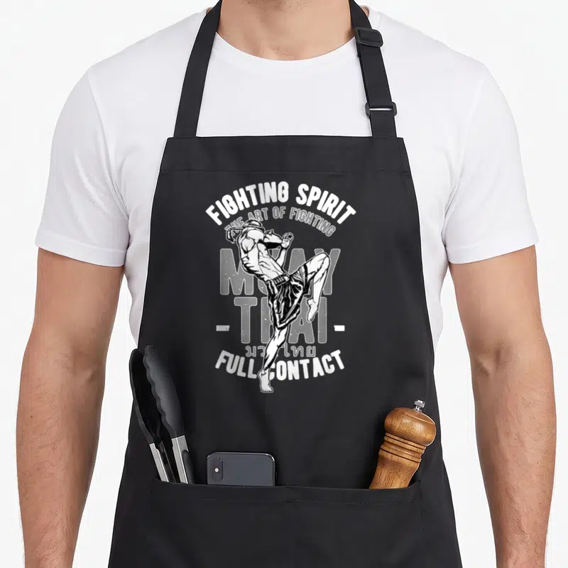 Tablier de cuisine noir avec illustration blanche d'un lutteur de Muay Thai effectuant un coup de pied élevé.