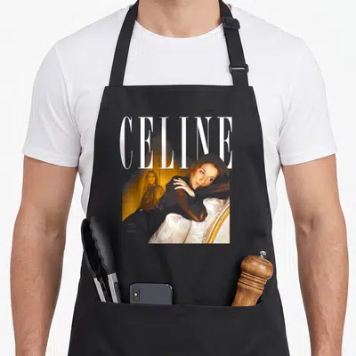 Tablier de cuisine noir avec portrait de Celine Dion et le mot CELINE en typographie blanche élégante.