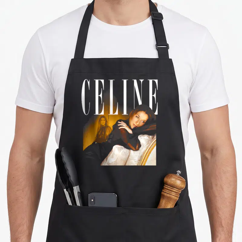 Tablier de cuisine noir avec portrait de Celine Dion et le mot CELINE en typographie blanche élégante.