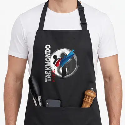 Tablier de cuisine noir avec silhouette de taekwondo et symbole Ying Yang rouge et bleu.
