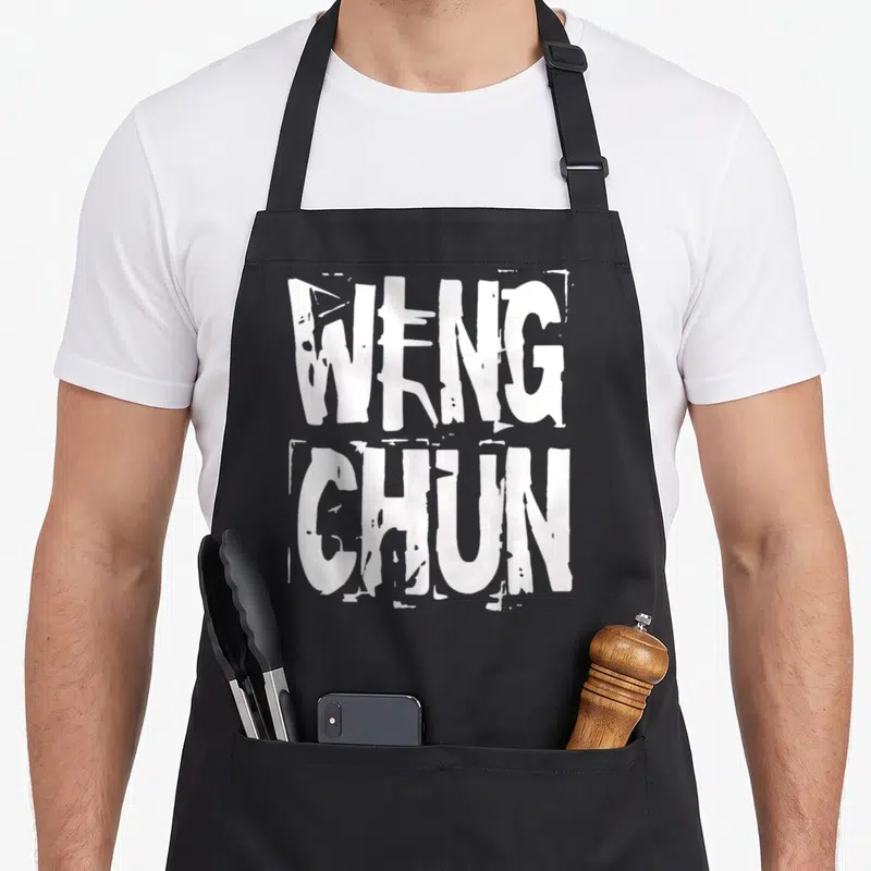 Tablier de cuisine noir avec l'inscription Weng Chun en grandes lettres blanches au style graffiti et éraflé.