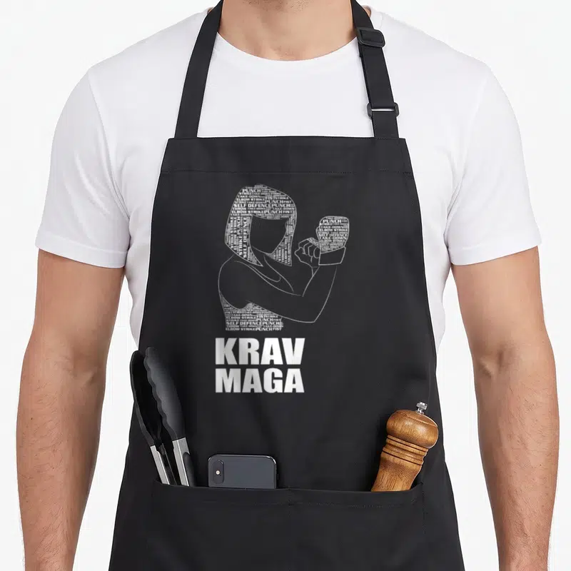 Tablier de cuisine noir avec silhouette typographique d'auto défense et texte Krav Maga en blanc.