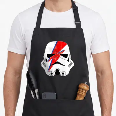 Tablier de cuisine noir avec un casque Stormtrooper blanc traversé par un éclair rouge et bleu stylisé.