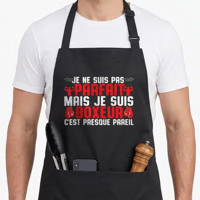 Tablier de cuisine noir avec inscription Je ne suis pas parfait mais je suis boxeur c'est presque pareil et gants de boxe rouges.