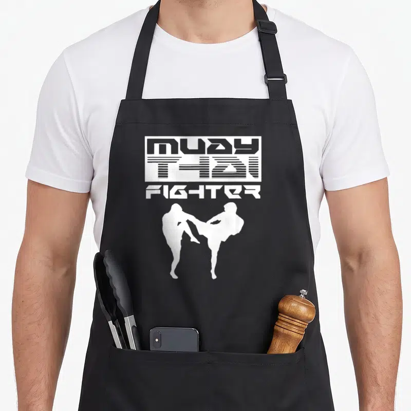 Tablier de cuisine noir avec silhouette blanche de deux boxeurs Muay Thai et texte géométrique FIGHTER.