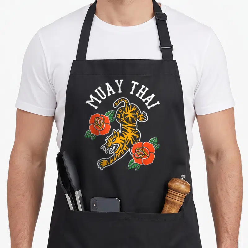 Tablier de cuisine noir avec illustration d'un tigre sautant et de roses rouges au style tattoo.