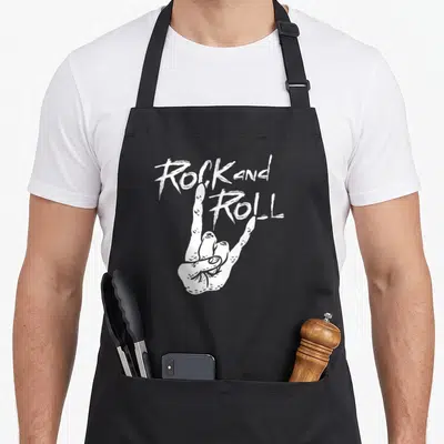 Tablier de cuisine noir avec main blanche formant les cornes du diable et texte Rock and Roll au-dessus.