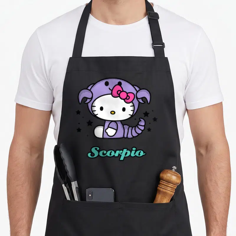 Tablier de cuisine noir avec Hello Kitty en déguisement de Scorpion violet entouré d'étoiles noires et du texte Scorpio.