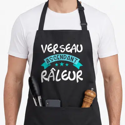 Tablier de cuisine noir avec inscription Verseau ascendant râleur et ruban turquoise orné de trois étoiles.