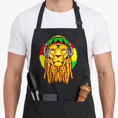 Tablier de cuisine noir avec illustration colorée d'un lion aux dreadlocks portant un casque audio et un bonnet tricoté.