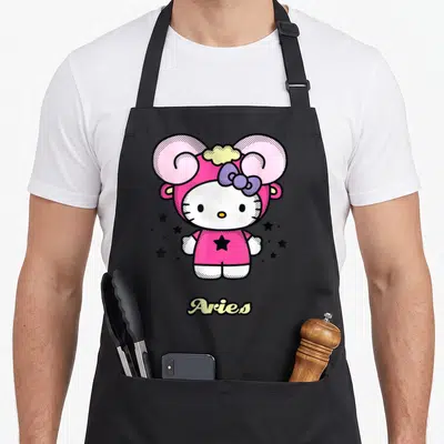 Tablier de cuisine noir avec Hello Kitty en costume de Bélier rose et l'inscription Aries en bas.