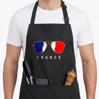 Tablier de cuisine noir avec lunettes de soleil aux verres tricolores et le mot FRANCE imprimé en blanc.