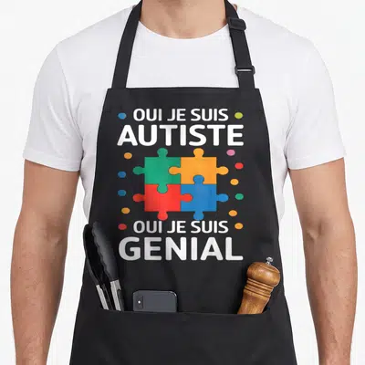 Tablier de cuisine noir avec le texte blanc Oui je suis autiste et génial autour d'un puzzle multicolore.