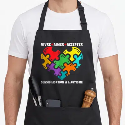 Tablier de cuisine noir avec un cœur de puzzle multicolore et le texte Vivre Aimer Accepter Sensibilisation à l'autisme.