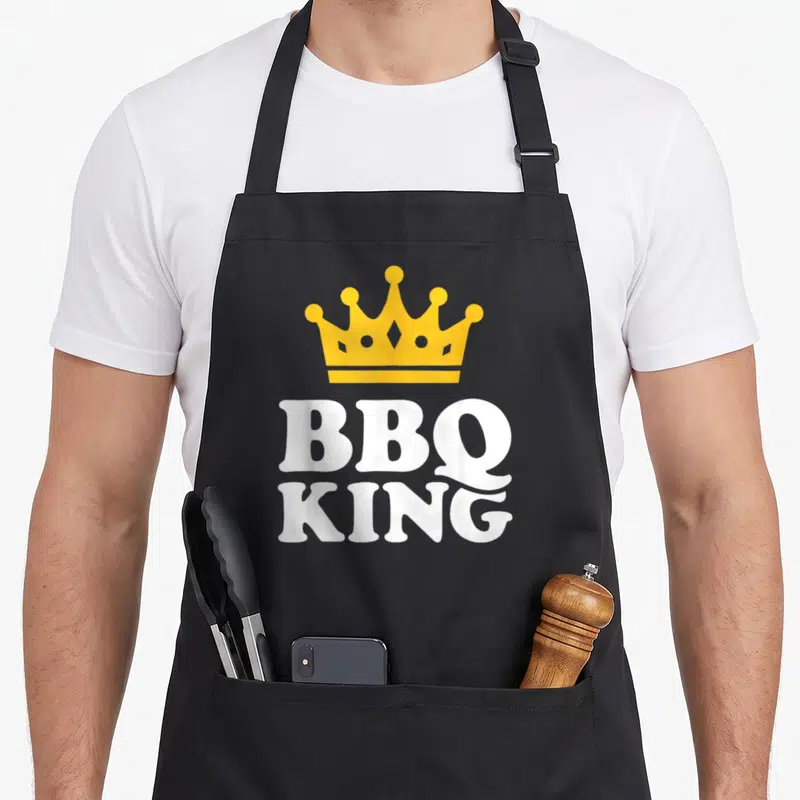 Tablier de cuisine noir avec une couronne jaune et l'inscription BBQ King en lettres blanches épaisses.
