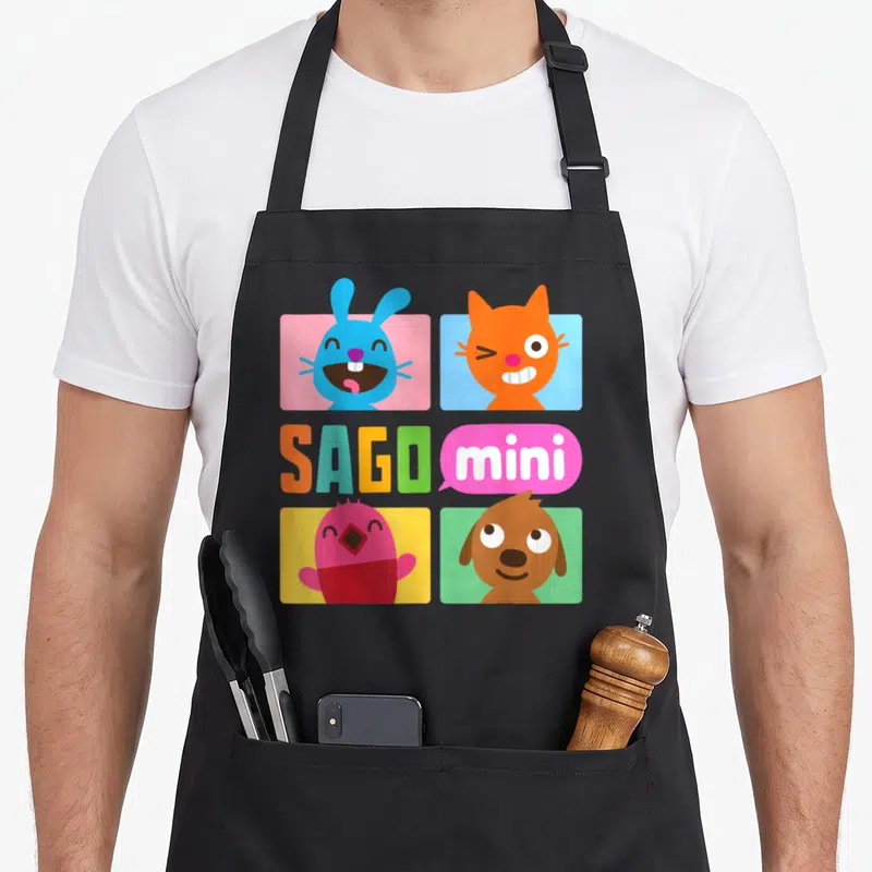 Tablier de cuisine noir avec les têtes colorées de Jack, Jinja, Robin et Harvey sur fond de cases pastel et le texte Sago mini.