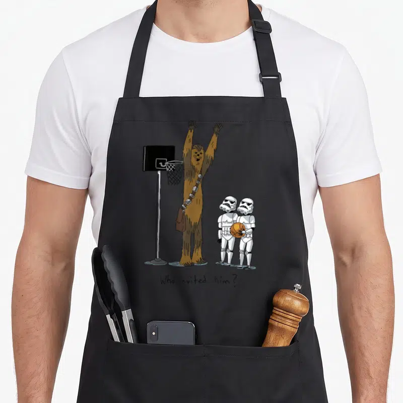 Tablier de cuisine noir avec une illustration de Chewbacca jouant au basketball face à deux Stormtroopers.