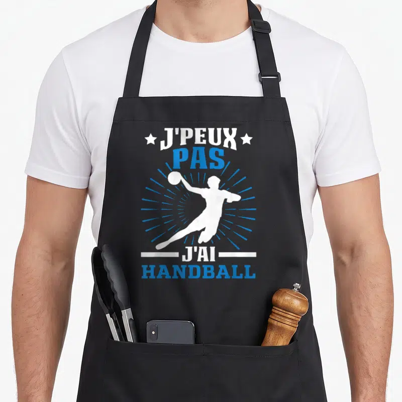 Tablier de cuisine noir avec silhouette handballeur et texte J'peux pas j'ai handball en blanc et bleu.