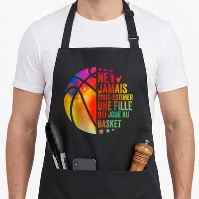Tablier de cuisine noir avec une balle de basket colorée en aquarelle et le texte Ne jamais sous-estimer une fille qui joue au basket.