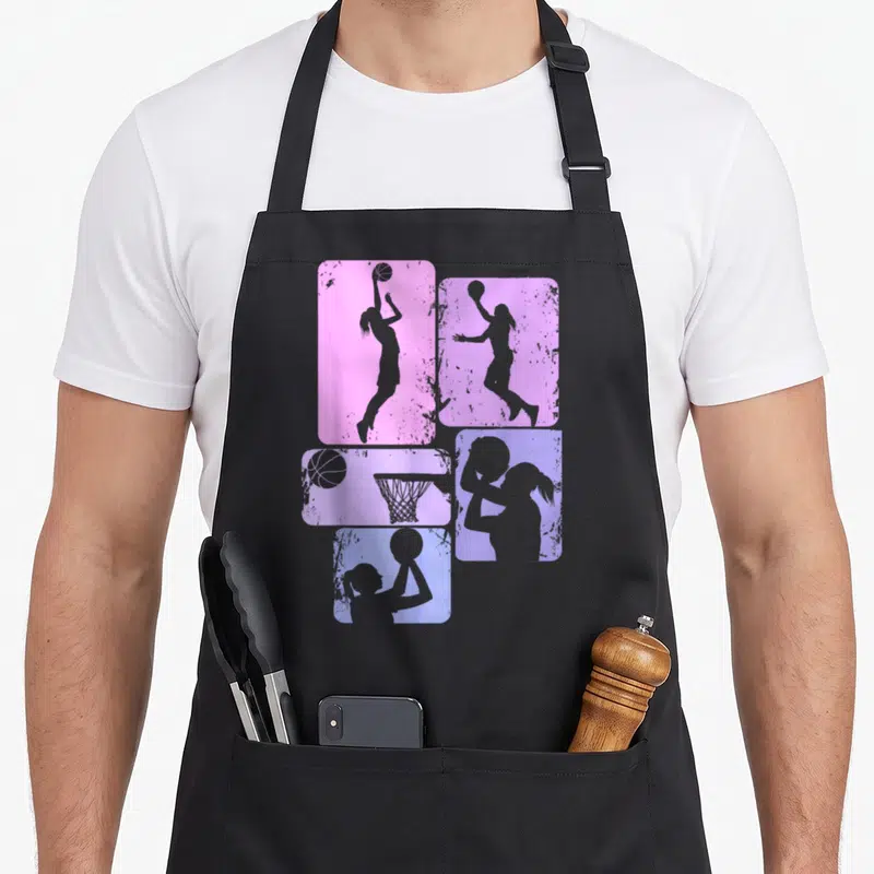 Tablier de cuisine noir avec quatre rectangles rose et violet montrant des silhouettes de joueuses de basketball et un panier.