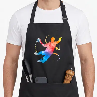 Tablier de cuisine noir avec silhouette aquarelle d'un joueur de handball en action multicolore.