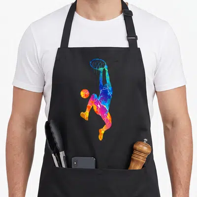 Tablier de cuisine noir avec silhouette colorée d'un joueur de basketball effectuant un dunk dynamique.