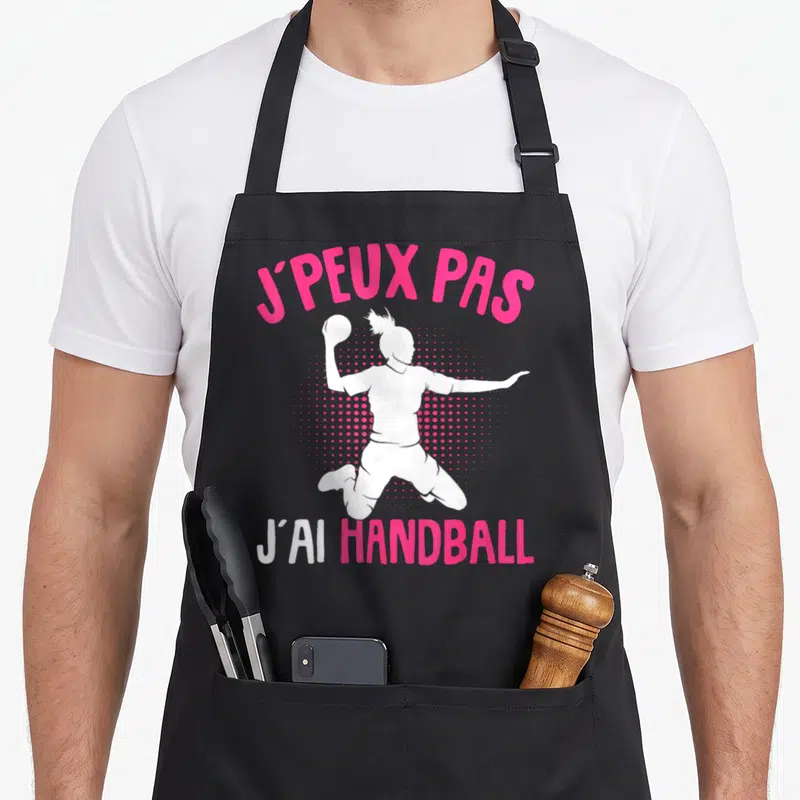 Tablier de cuisine noir avec silhouette handballeuse et texte J'peux pas j'ai handball en rose et blanc.