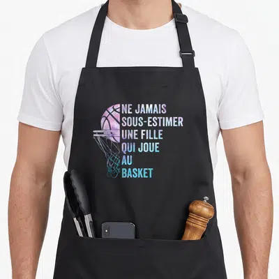 Tablier de cuisine noir avec illustration d'un panier de basket et texte aux couleurs dégradées rose et bleu.