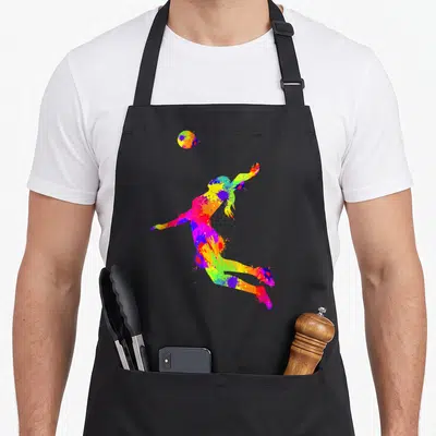 Tablier de cuisine noir avec silhouette de joueuse de volley-ball aux couleurs vives et effet éclaboussure.