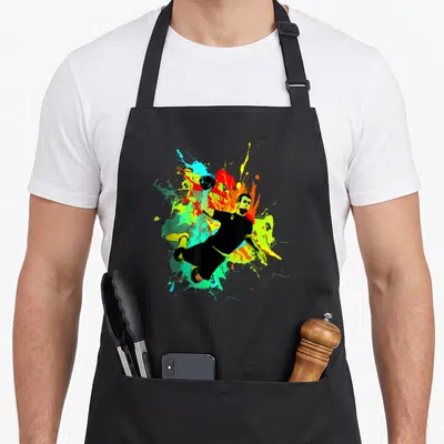 Tablier de cuisine noir avec une illustration dynamique d'un joueur de handball sautant au milieu d'éclaboussures multicolores vives.