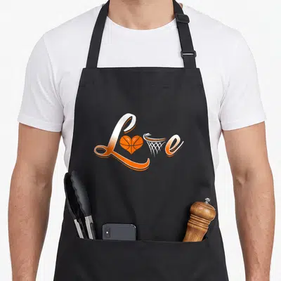 Tablier de cuisine noir avec le mot Love stylisé en orange et blanc, intégrant un ballon-forme-cœur et un panier de basket.