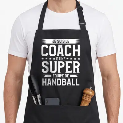 Tablier de cuisine noir avec inscription blanche Je suis le coach d'une super équipe de handball et des étoiles décoratives.