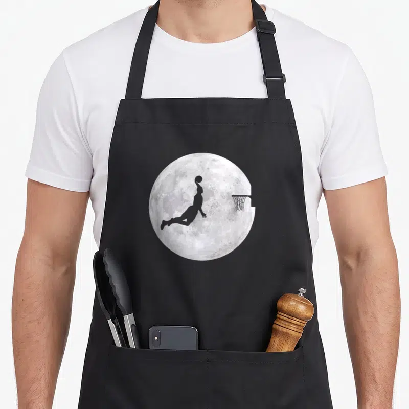Tablier de cuisine noir avec silhouette joueur de basket devant une pleine lune et un panier.