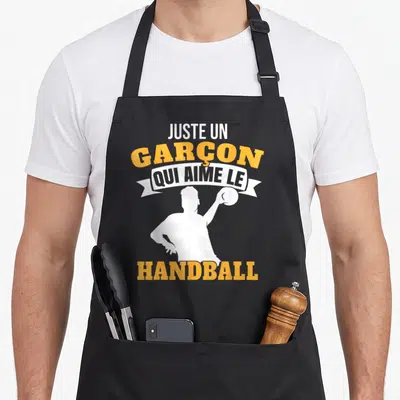 Tablier de cuisine noir avec une silhouette de handballeur et le texte Juste un garçon qui aime le handball