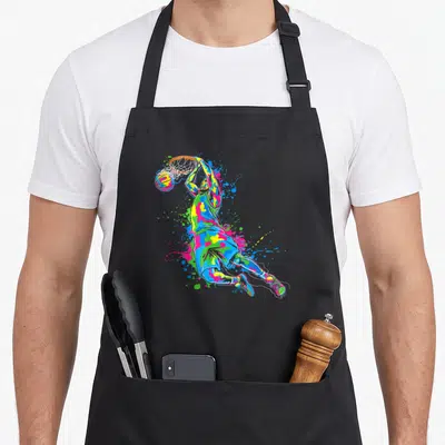 Tablier de cuisine noir avec illustration colorée d'un joueur de basket en maillot effectuant un panier dynamique.