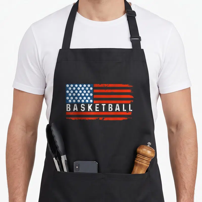 Tablier de cuisine noir avec un drapeau formé de ballons de basket et l'inscription BASKETBALL en blanc.