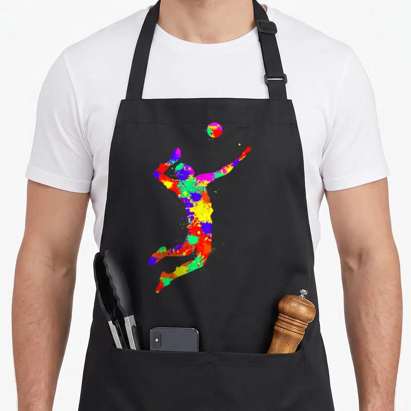 Tablier de cuisine noir avec une silhouette multicolore d'un joueur de volley en action, style éclaboussure de peinture.