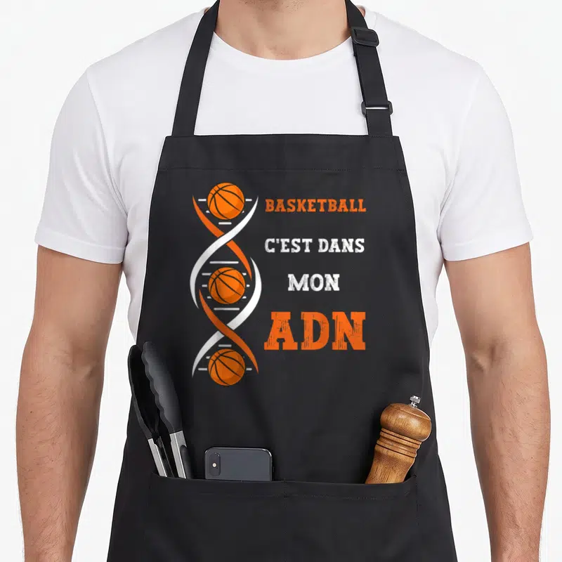 Tablier de cuisine noir avec une double hélice d'ADN contenant des ballons de basket et le texte Basketball c'est dans mon ADN.