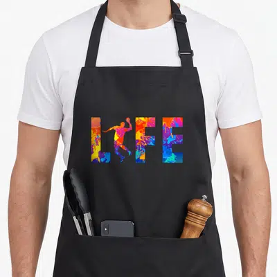 Tablier de cuisine noir avec le mot LIFE en lettres multicolores et une silhouette de joueur de handball au centre.