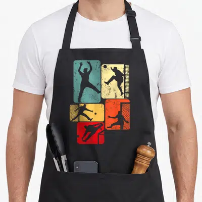 Tablier de cuisine noir avec des silhouettes de gardien de handball sur fonds colorés et effet vieilli.