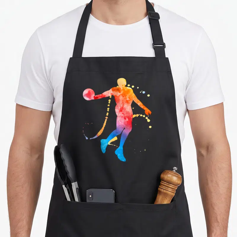 Tablier de cuisine noir avec une silhouette de joueur de basket en aquarelle colorée.