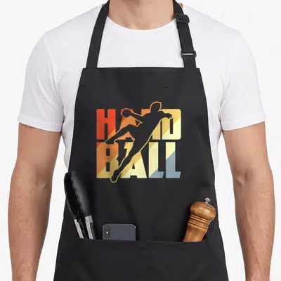 Tablier de cuisine noir avec une silhouette de joueur de handball sur le mot HANDBALL multicolore