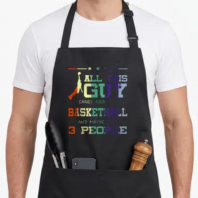 Tablier de cuisine noir avec une silhouette de joueur de basket et le texte « ALL THIS GUY CARES ABOUT IS BASKETBALL AND MAYBE LIKE 3 PEOPLE » multicolore.