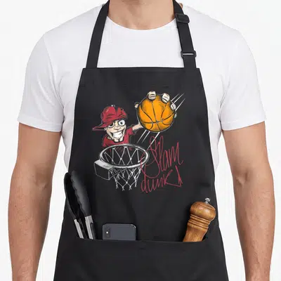Tablier de cuisine noir avec illustration d'un basketteur vintage effectuant un slam dunk au-dessus d'un panier.