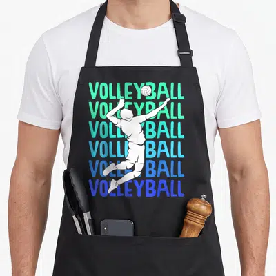 Tablier de cuisine noir avec silhouette blanche de joueur de volley et texte VOLLEYBALL en dégradé vert et bleu répété six fois.