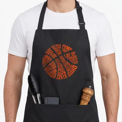 Tablier de cuisine noir avec un ballon de basket-forme de mots en orange vif incluant Lay Up et Center Guard.