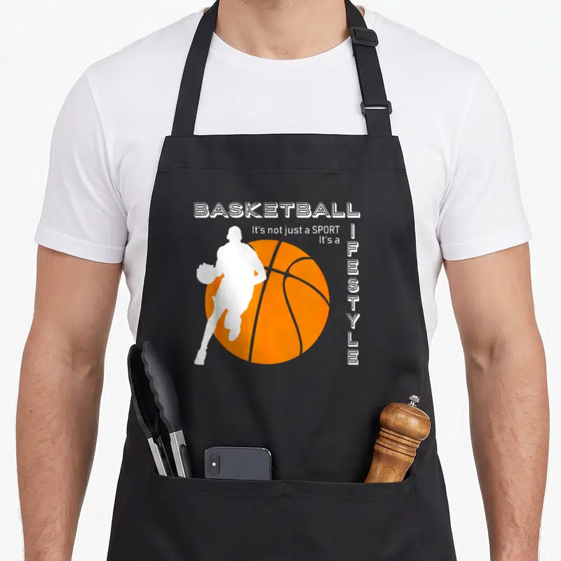Tablier de cuisine noir avec silhouette joueur de basket blanc sur balle orange et texte Basketball c'est un style de vie