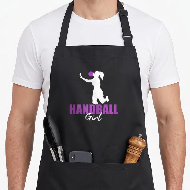 Tablier de cuisine noir avec silhouette blanche de joueuse de handball et texte Handball Girl en violet.